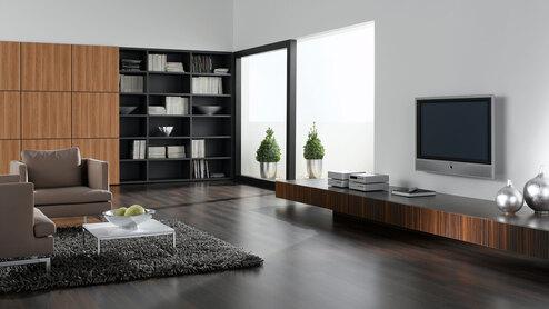 Wohnraumimpression mit dunklem Mobiliar Wohnraumimpression mit verschieden dunklen Holzoberflächen für Einbauschrank, Sideboard und Bodenbelag