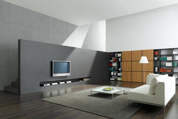 Wohnraumimpression mit Fernsehwand zur Treppe Offene Wohnraumimpression mit grauer TV-Trennwand zur Treppe und Einbauregal aus Holz und weißem Sofa